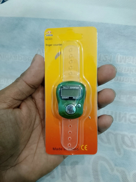 Digital finger counter on a yellow card held by a hand against a light blue fabric background