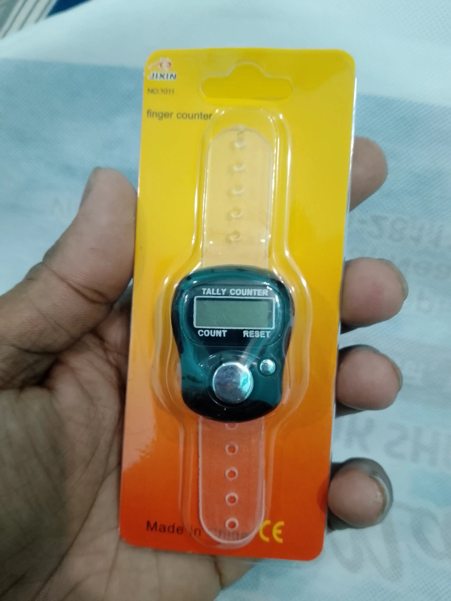 Finger counter on a yellow card held by a hand