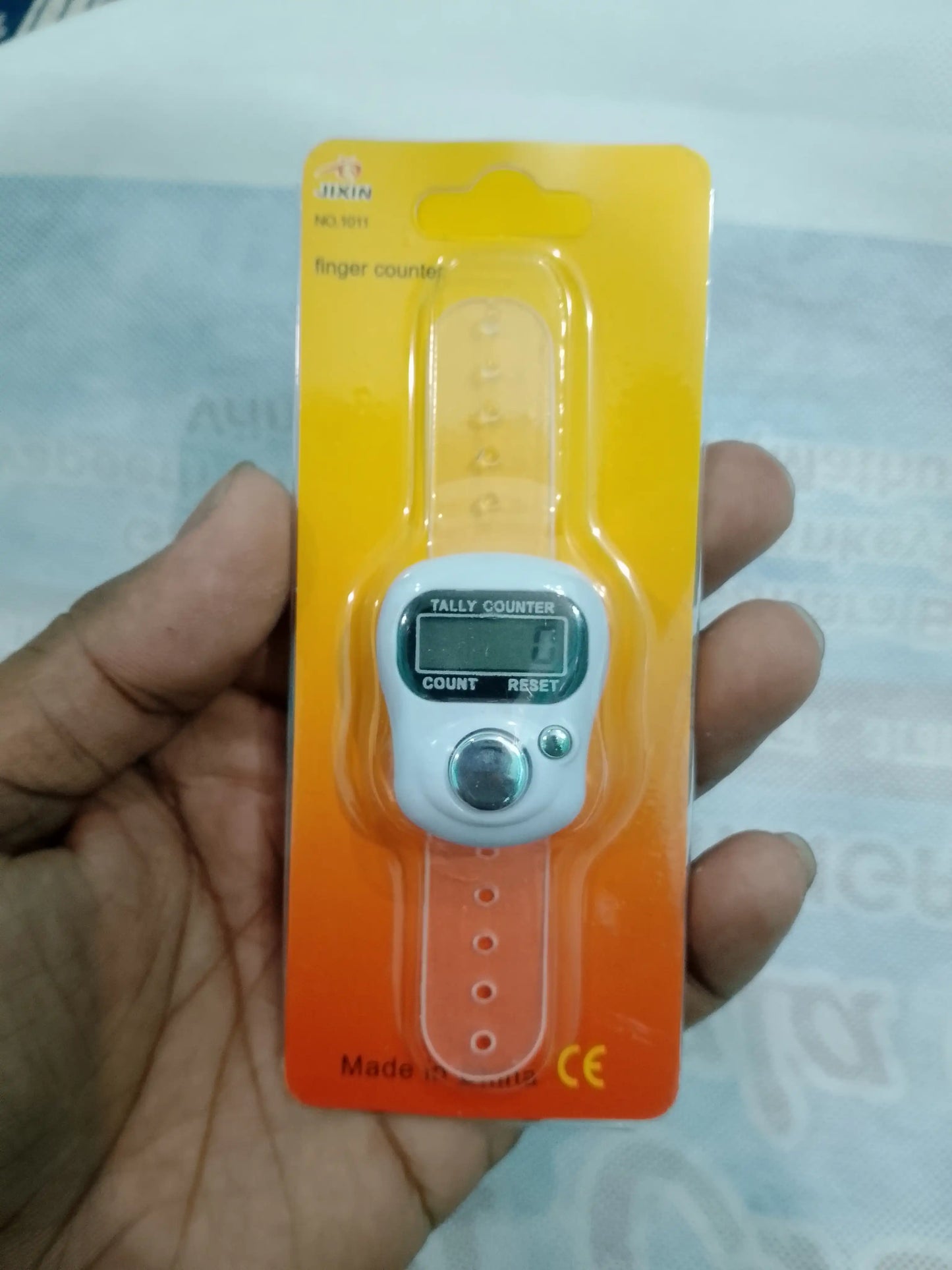 Finger pulse counter held by a hand with a clear background