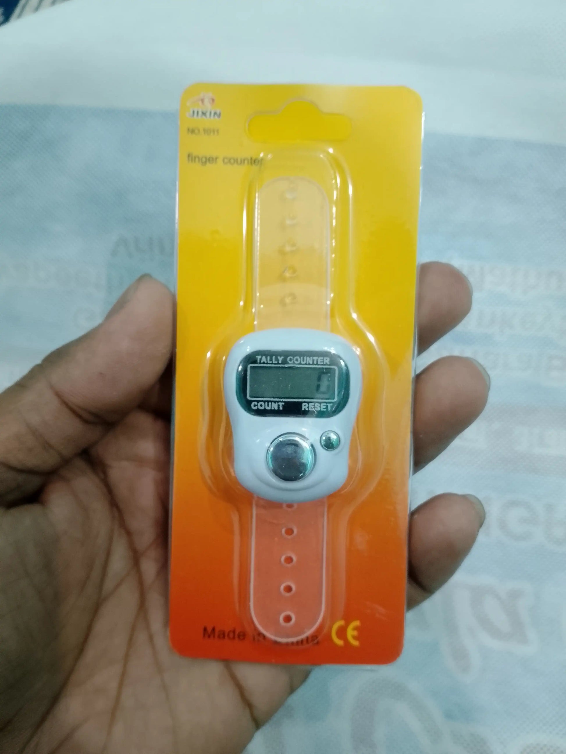 Finger pulse counter held by a hand with a clear background