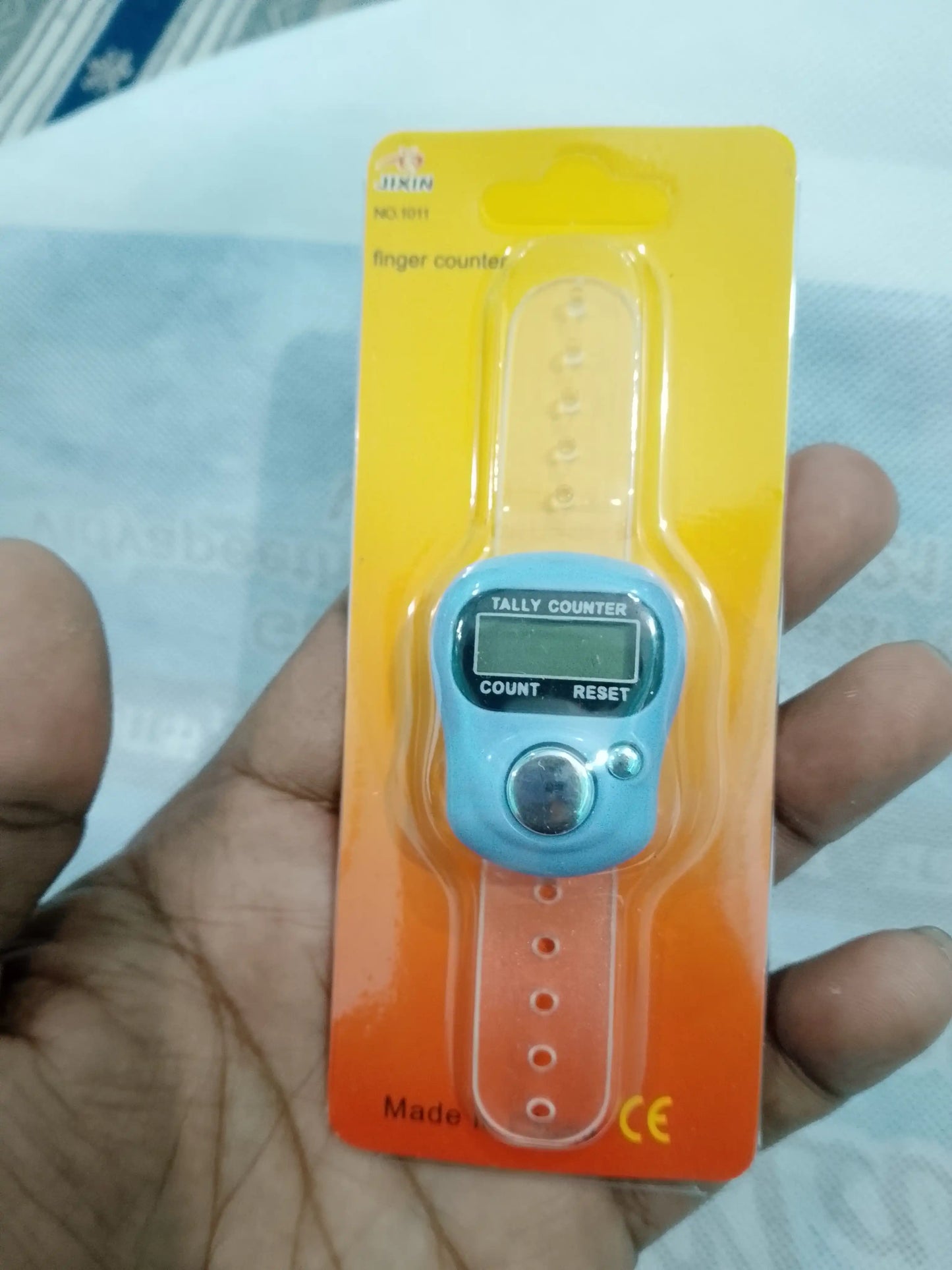 Finger counter device on a yellow card held by a hand