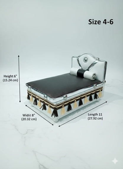 Silver Bed for Laddu Gopal Radha Krishna with black leather top and tassels on a white surface with teal background
