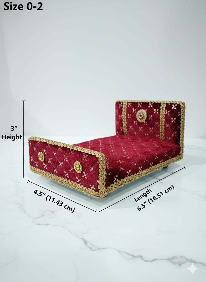 Red velvet bed with gold trim on a white surface against a teal background for Laddu gopal and Radha Krishna
