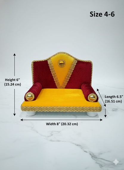 Singhasan for Gopal ji with red and yellow cushions on a white surface with teal background